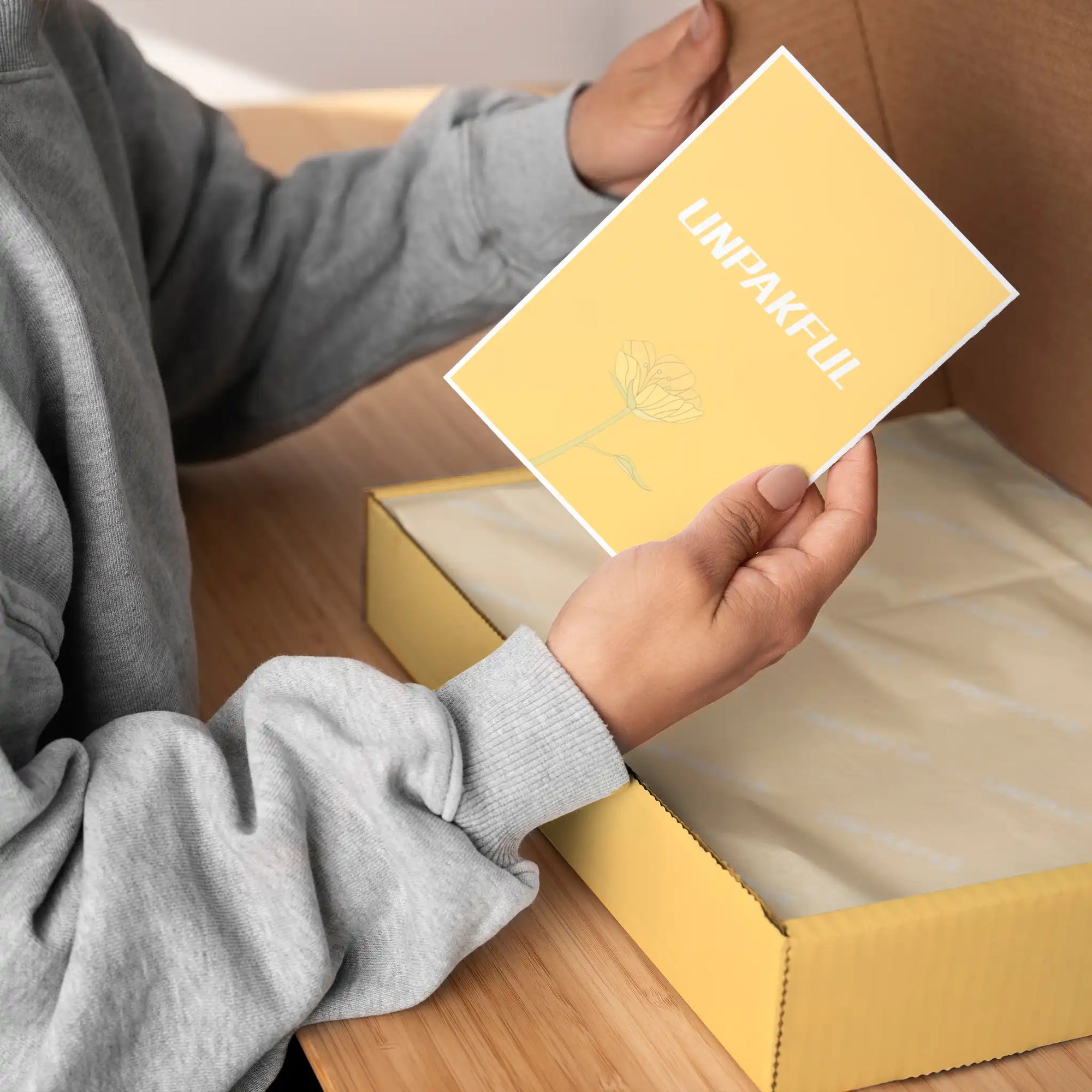 Person holding a custom card with a floral design, ready to include in unique product packaging.